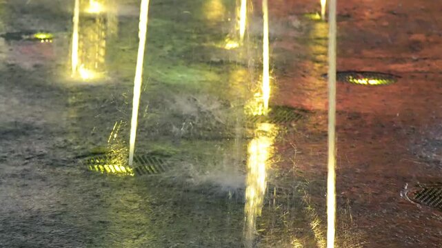 Water fountain jets spraying at night in a park illuminated New York City