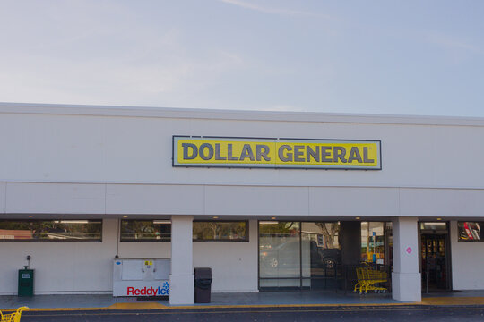 Exterior view of a Dollar General storefront in a suburban strip mall with prominent yellow signage. Editorial Use Only March 6, 2026 St. Petersburg, FL USA. shopping carts and a quiet parking area, e