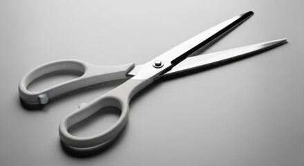 Obraz premium Open scissors on a white surface, ready for cutting.