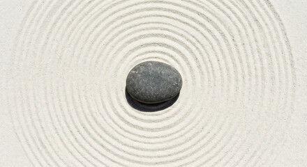 Naklejka premium Minimalist Zen Garden with Smooth Grey Stone Centered in Circular Raked Sand Patterns