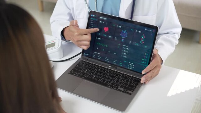 Doctor showing medical test results on a laptop to a female patient in a modern clinic.