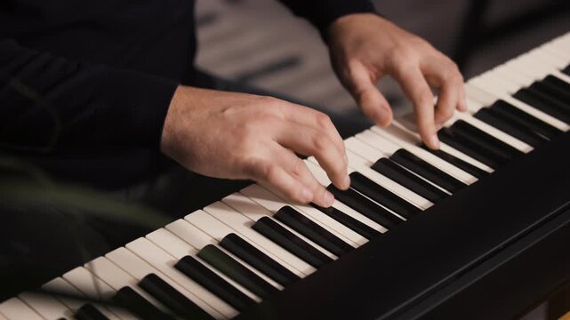 Beginner pianist, male hands practicing on a electronic piano keyboard at home