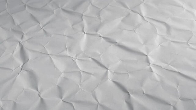 Close-up view of a white crumpled paper texture with deep shadows and highlights.