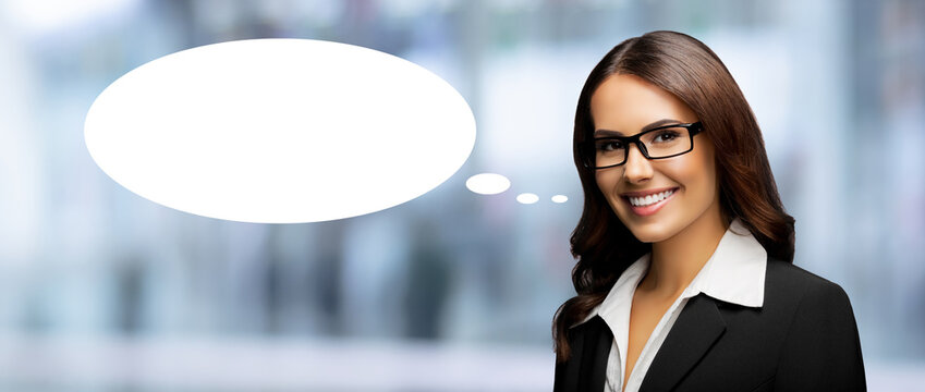 Portrait image - happy smile business woman businesswoman teacher, bank manager. Brunette girl wear black eye glasses, eyeglasses, suit jacket. Blurred office background. White empty speech bubble