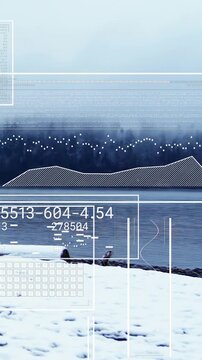 Vertical video: Snowy shoreline receiving climate feed, HUD panels rising, stacking, showing charts