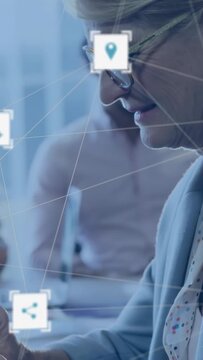 Vertical video: Receiving alert, woman with glasses and blazer reading device in office, UI icons
