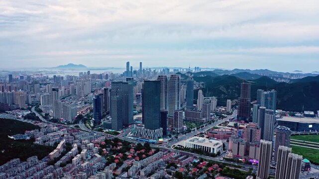 Dalian China Downtown Skyline with Modern Towers and Surrounding Mountains