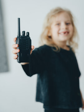 child girl demonstrates a wireless radio. Communication with the child and home safety.
