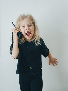 A child girl screams into a radio and listens. Communication with the child.
