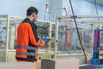 Workers in safety gear inside a factory check equipment and products on production and...