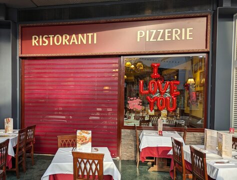 Detalle de fachada de restaurante La Tagliatella, con decoraci&oacute;n para San Valent&iacute;n con globos y texto I LOVE YOU, en centro comercial Islazul, Madrid, Espa&ntilde;a, 14 de febrero de 2026