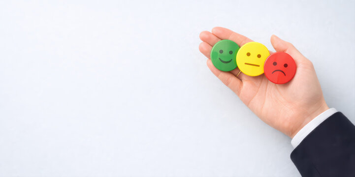 Green smiley face Yellow neutral face Red sad face Hand holding emoticons Customer feedback Emotion Business concept Positive emotion Negative emotion Neutral emotion Human hand White