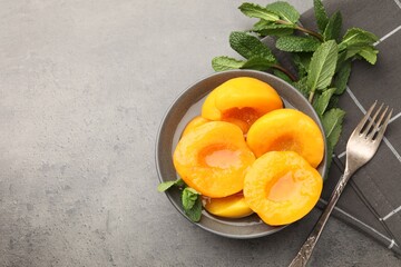 Pickled peaches and mint leaves on grey table, flat lay. Space for text © New Africa