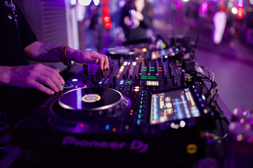 Obraz premium DJ Mixing Music on a Console at a Nightclub