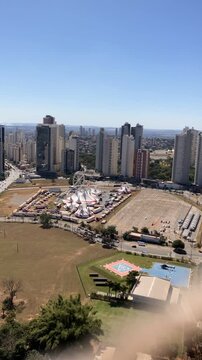 Time lapse of helicopter landing on urban helipad with carnival celebration nearby in a busy city, showcasing aerial transport, vibrant festival atmosphere, and modern city life