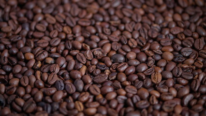 Fototapeta premium Coffee beans closeup, Warm roasted beans detailed shot, Closeup of glossy roasted coffee beans with soft lighting, Detailed view of warm brown roasted coffee beans with oily sheen