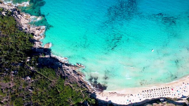 Rena Bianca beach top-down aerial. Drone flight to Longonsardo tower. Sardinia Italy. Santa Teresa Gallura. Turquoise sea water. Historical landmark. Mediterranean coast. 4K overflight