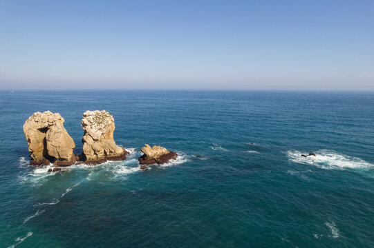 Urro del Manzano at sunset, Liencres, Spain. Rock formation natural arch bridge in Arnia Costa Quebrada.. Cantabria landscape, sea and beautiful colores.