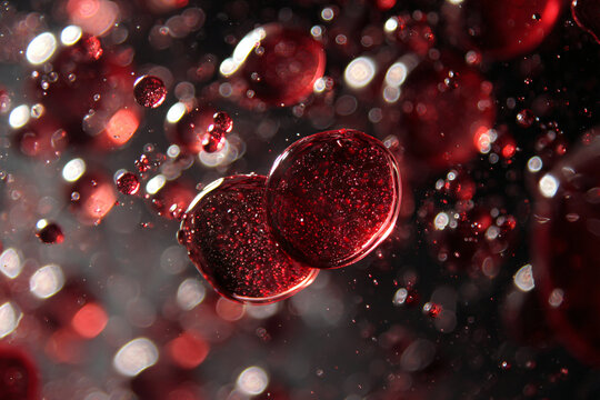 Close-up of vibrant red bubbles suspended in a liquid, creating a mesmerizing abstract pattern.