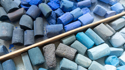 Blue gray soft pastels chalk collection in wooden storage case for creativity. Painter's multicolor background.