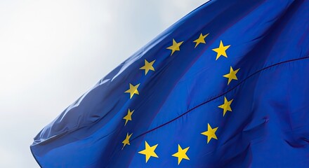 European union flag waving in the wind with yellow stars on blue background