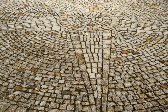 Abstraktes Motiv mit Boden aus grau-braunen Pflastersteinen aus Marmor in Sternform 