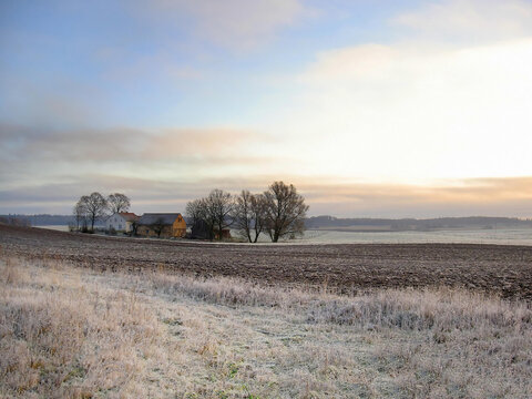 Rural landscape in the morning with the first snow in the fields. Blue sky and sunrise, Northern Poland.