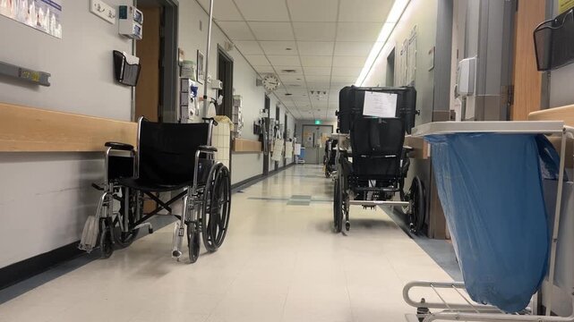 Hospital hallway with wheelchairs and medical laundry cart.
