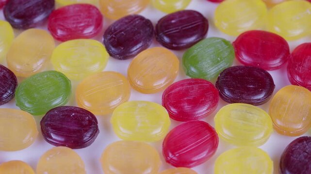 Colorful candy closeup. Bright candies with shiny shells. Multicolored sweets sparkling under bright light. Vivid confectionery with translucent shells and sugar crystals gleam
