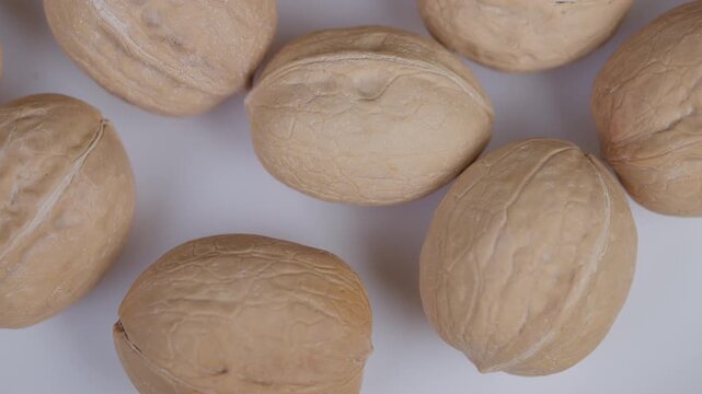 Walnuts on white. Detailed image emphasizing walnut texture and natural qualities. Arranged walnuts highlighting rough shells and fine creases in soft studio lighting