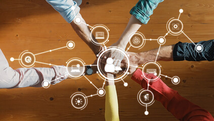 This image captures a diverse group of hands coming together, symbolizing teamwork and digital...
