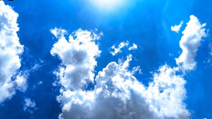 A view of a bright blue sky with drifting white clouds. The sun was shining brightly, providing a bright and refreshing effect.