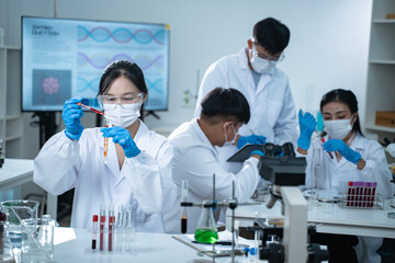 In the laboratory, several researchers conduct blood tests and analysis on samples, using science...