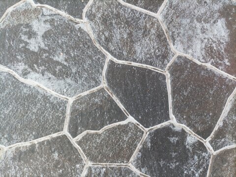 Seamless dark grey flagstone pavement texture. Natural stone walkway with white grout lines for outdoor design.