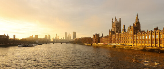 Obraz premium London skyline panorama with Palace of Westminster and River Thames at sunrise, reflecting golden light