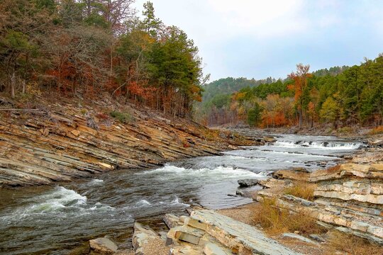 Mountain Fork River Flowing Over Layered Rock With Autumn Forest in Broken Bow Oklahoma