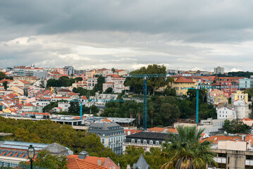 Obraz premium panoramic cityscape of lisbon with red rooftops and dramatic clouds