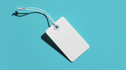 Fototapeta premium Blank white gift tag on turquoise background with string