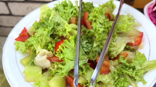Lettuce leaves and tomatoes Fresh salad leaves on rotating bckground. Top view. Green Raw organic vegetables. Vegan diet and vegetarian food concept.