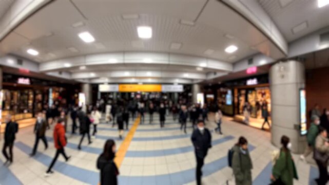 TOKYO, JAPAN - FEB 2026 : Blurred view of crowd of people walking at the busy station in night time rush hour. Many commuters going home. Japanese business people, job and lifestyle concept.
