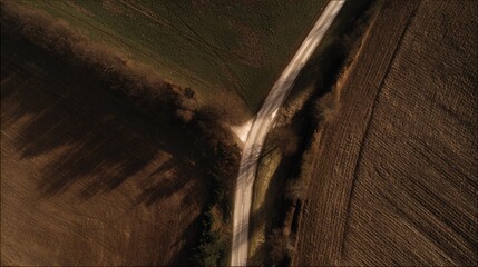 Rural dirt road crossroads in fields, showing agricultural landscape.