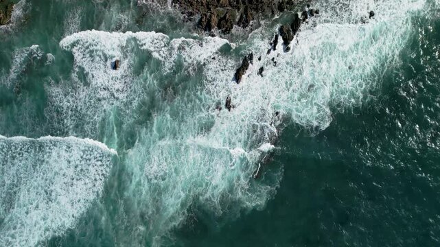 Aerial view of Gijon coastline in Asturias, powerful sea waves with white foam crashing into rocky cliffs, scenic Mediterranean travel destination, Spain, 4K
