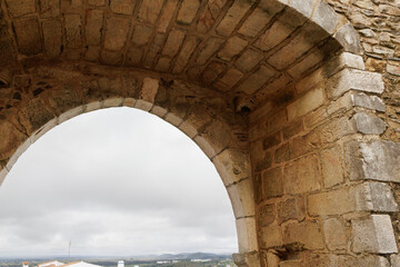 Fototapeta premium Medieval stone arch framing estremoz city in alentejo