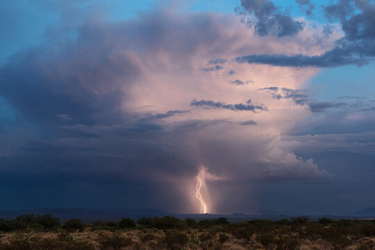 Distant thunderstorm and lightning strike at blue hour