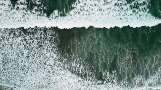 Aerial view of Gijon coastline in Asturias, powerful sea waves with white foam crashing into rocky cliffs, scenic Mediterranean travel destination, Spain, 4K