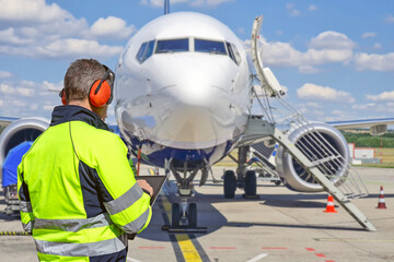 Airport ground crew worker using tablet during aircraft ground handling. © Rafa Jodar