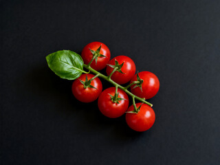 Fresh cherry tomatoes with basil leaf on black background, healthy food