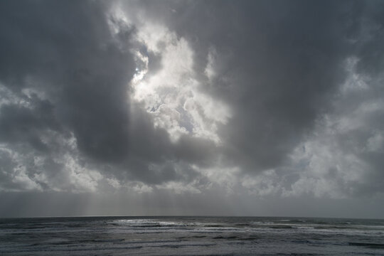 USA, WA, Olympic Peninsula, South Beach.  Light striking the pacific ocean on the horizon, on a stormy day.