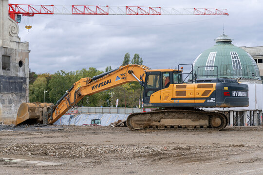 Nancy, France - October 3rd 2020 : View on a yellow crawler excavator Hyundai HX 330NL for earthworks on a construction site with a tower crane in the background.
