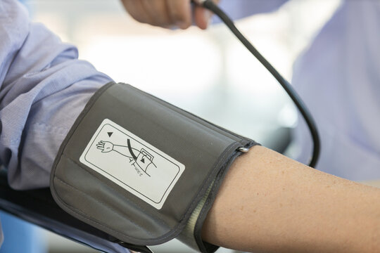 Doctor measuring blood pressure of senior patient during medical examination, close up healthcare checkup with sphygmomanometer, concept of elderly care, diagnosis, monitoring, preventive healthcare.
